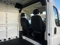 Interior view of a 2021 RAM Promaster showing two black front seats and an empty cargo area with white walls