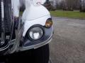 Close-up of the front corner of a 2010 International 7300 featuring chrome detailing and two headlights one clear and one amber