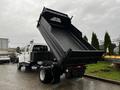 A 2005 GMC C5 Duramax dump truck with its bed raised, showcasing the large cargo area designed for transporting materials