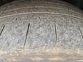 Close-up of a worn tire tread featuring distinct grooves and a rough texture indicating significant use