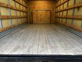 Interior of a 2021 Ford E-450 truck showing a clean wooden floor and empty cargo space with vertical wooden panels along the sides