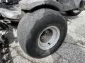 Close-up of a worn tire on a 2015 Jacobsen Eclipse golf course mower showcasing a silver rim and heavily treaded black rubber tire