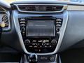 The dashboard of a 2021 Nissan Murano featuring a touchscreen display with audio controls climate settings and a gear shift