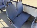 A pair of blue upholstered seats with safety belts mounted in a vehicle interior
