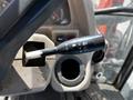 Close-up of the control lever in a 2011 Kubota M8540D tractor featuring a directional indicator and a control for lights and wipers