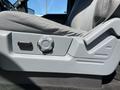 Close-up of the seat adjustment controls in a 2014 Ford F-150 with a grey fabric seat and a round dial for height adjustment