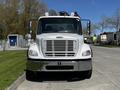 A white 2012 Freightliner M2 112 front view featuring a chrome grille and several lights on the roof