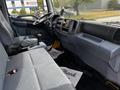 Interior of a 2006 Hino 268 truck showing two gray seats with a gear shift and dashboard controls