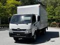 A white 2018 Hino 195 box truck with a clear cargo area and side mirrors parked in a lot