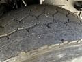 Close-up of a worn tire from a 2005 Volvo VND 122 showing visible tread wear and cracks on the surface