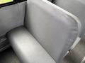A gray seat inside a 2014 Freightliner B2 bus with a smooth texture and simple design