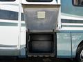 A 2000 Ford Motorhome with an open storage compartment revealing a clear plastic bin inside