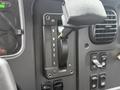 A gear shift lever and control panel of a 2019 Freightliner M2 with labeled positions for reverse neutral drive and low gears