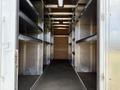 A 2016 Ford Transit with an empty interior featuring metal shelving units attached to the walls and a spacious floor without any cargo