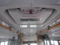 Interior view of a 2016 Chevrolet Express showing an emergency exit sign on the ceiling with yellow safety bars visible along the interior walls