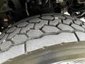 Close-up of a truck tire showing a rugged tread pattern designed for traction and durability on various surfaces