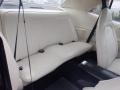Interior view of a 1974 Dodge Challenger featuring white leather rear seats with vertical stitching and a center armrest