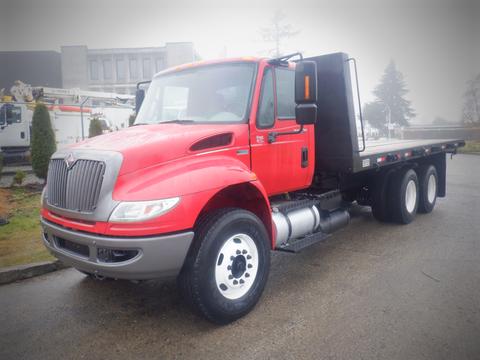 A red 2011 International 4400 truck with a flatbed design featuring large wheels and a prominent front grille
