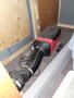 A 2022 Royal Camper with a black and red heating unit and a connected black ducting hose lying on the floor of the camper interior