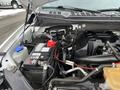 Engine compartment of a 2017 Ford F-150 with a visible battery coolant reservoir and various engine components