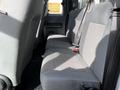 Interior view of the rear seating area of a 2011 Ford F-450 SD with gray fabric upholstery and seat belts