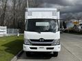 Front view of a 2018 Hino 195 box truck with a white body and a silver roof featuring vents and a prominent logo on the grille