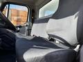 Interior of a 2016 Freightliner M2 106 with a driver's seat and a passenger seat visible, both covered in black fabric