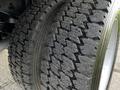 Close-up of two worn tires on a 2007 Ford F-550 showcasing deep tread patterns and visible signs of use