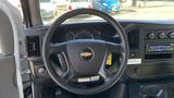 The interior of a 2011 Chevrolet Express showing the steering wheel dashboard and control panel