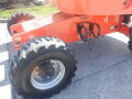 A 2008 JLG Boom Lift with large black tires and an orange body showing mechanical components and identification labels