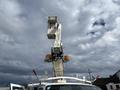 A 2008 Ford Econoline van with an elevated bucket lift on top and safety lights
