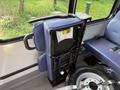 A blue upholstery seat in a Chevrolet Express with a folded backrest displaying a warning label attached to it