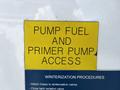 A 2009 Ford F-550 with a yellow and blue access label for pump fuel and primer pump along with winterization procedures
