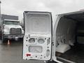 A 2011 Ford Econoline van with its rear doors open displaying a spacious interior area designed for cargo transport