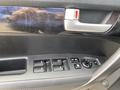 A close-up view of the driver's side door panel of a 2015 Kia Sorento featuring window control buttons and a door handle