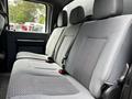 A gray interior of a 2016 Ford F-550 showing the back seat with three headrests and seatbelts