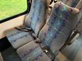 Two grey seats with blue and teal swirling designs and seatbelts in a vehicle interior