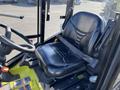 A black leather seat with a seatbelt inside the cabin of a Kubota F3990 tractor featuring a steering wheel and control panel