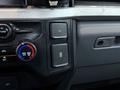 Interior controls of a 2023 Ford F-250 including climate control knobs and electrical outlet buttons