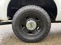 Close-up of a black wheel and tire from a 2008 Ford F-250 SD with rugged tread pattern and Ford logo in the center