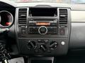 Dashboard of a 2012 Nissan Versa featuring a radio with digital display and control knobs for climate and audio settings