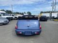 A blue 2007 Chrysler PT Cruiser convertible with a black soft top is parked facing the camera, showcasing its rear design and tail lights