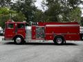 A red 1991 Sutphen Deluge fire truck with a shiny metal panel and various fire-fighting equipment on the side