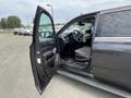 A black 2016 Chevrolet Tahoe with an open front door showing the interior dashboard and steering wheel