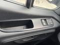 Interior door panel of a 2025 Mercedes-Benz Sprinter featuring controls for window operation and a built-in storage compartment