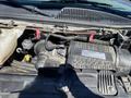 Engine compartment of a 2020 Chevrolet Express featuring a Vortec engine with various components and hoses visible