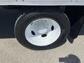A close-up of a black tire mounted on a white wheel of a 2008 Ford F-450 SD with the tire's tread and valve stem visible