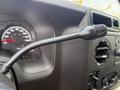 Close-up of the steering column and dashboard controls of a 2011 Ford Econoline showing the speedometer and an on/off switch