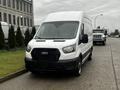 A white 2021 Ford Transit van is parked in the foreground with a black grille and large windshield