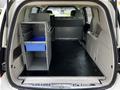 A 2011 Dodge Grand Caravan with an empty cargo space featuring a gray storage unit and a blue drawer positioned inside